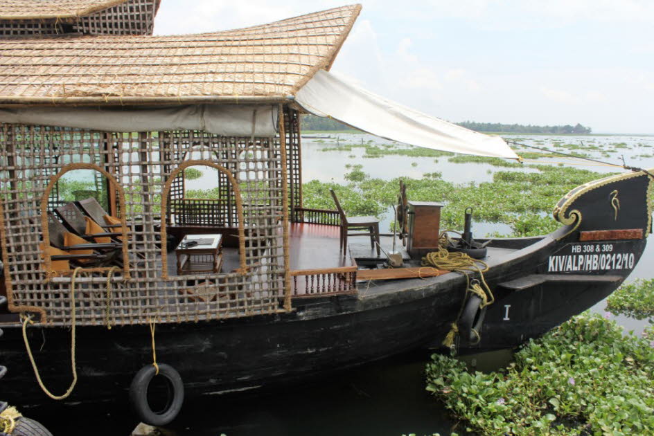 Reise durch die Backwaters auf einem Kettuvallam Hausboot: Ein Kettuvallam ist ein motorisiertes Hausboot, umgebaut aus einer ehemaligen Lastbarke, das vor allem in den Backwaters im indischen Bundesstaat Kerala eingesetzt wird. Es dient ausschließlich to