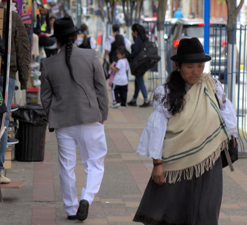 Otavalo: Traditionelle Kleidung: Frauen aus Otavalea tragen traditionell markante weiße gestickte Blusen mit ausgestellten Spitzenärmeln und schwarze oder dunkle Oberröcke mit cremefarbenen oder weißen Unterröcken. Lange Haare sind mit einem 30 cm langen 